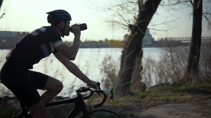 Cyclist cycling fitness riding road bike and drinking water