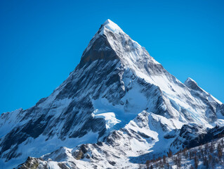 isolated mountain peak, snow - capped, clear blue sky