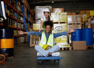 factory workers moving cart and having fun in the warehouse storage