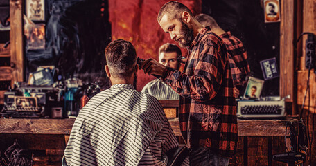 Man visiting hairstylist in barbershop. Barber works with hair clipper. Hipster client getting haircut. Bearded man in barbershop. Haircut concept - obrazy, fototapety, plakaty