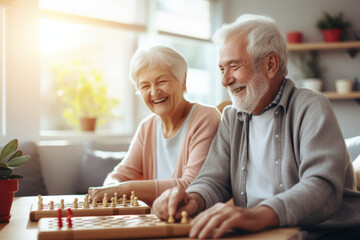 Beautiful loving couple in a retirement home. Senior man and a senior lady playing table game in a nursing home. Housing facility intended for the elderly people. - obrazy, fototapety, plakaty