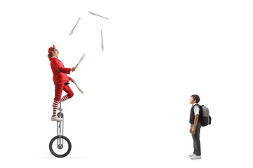 Schoolboy watching an acrobat riding a giraffe unicycle and juggling © Ljupco Smokovski