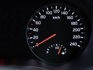 car speedometer on black background with fuel gauge