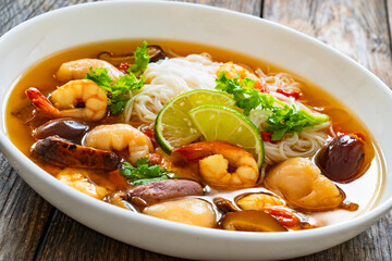 Yunnan hot pot - Chinese soup with shrimps on wooden table
