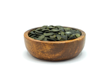 Pumpkin seeds in wooden bowl isolated on white background