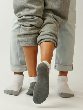 white and gray socks on man and woman feet closeup photo on white background