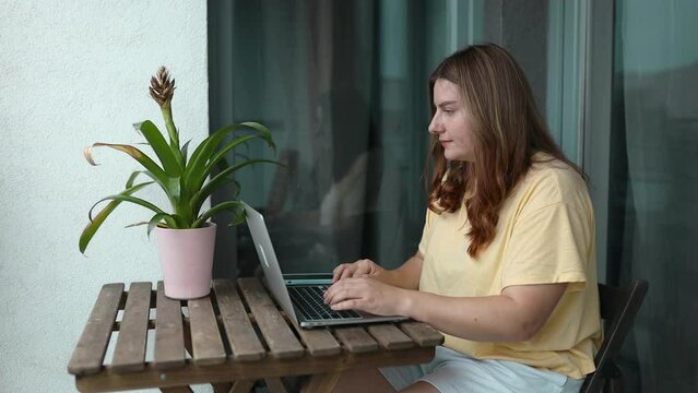 Concentrated at work. Confident young woman in smart casual wear working on laptop while sitting near window in creative office or cafe. High quality FullHD footage