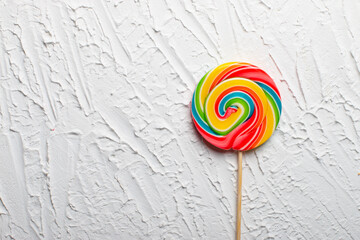 Bright multicolored lollipop on a white background. top view. sweets for the holiday. There is an empty space on the right for placing text or something else.