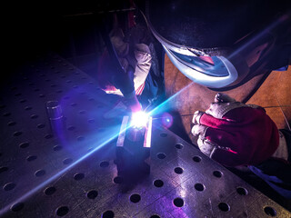 Welder is welding Tungsten Inert Gas welding, TIG weld for making new stainless flexible hose in...