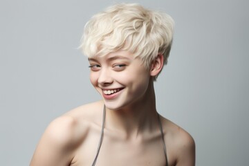 Portrait of a young Caucasian short hair blonde woman with a studio background