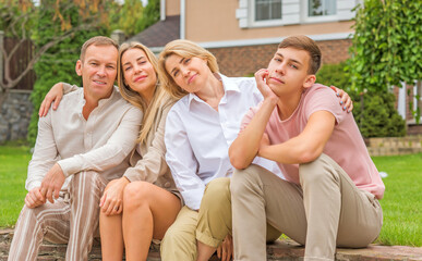 Fototapeta premium Portrait of happy family at home yard, relax at beautiful day, relationship and lifestyle of family values