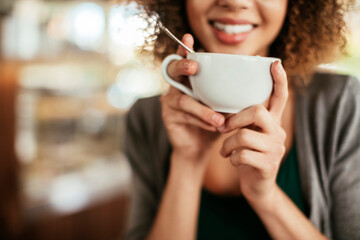 Young African American woman enjoying a cup of coffee alone in a cafe or bar