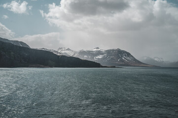 Mountain Range at the Coast of Iceland near Seydisfjordur during cloudy day, sea in front