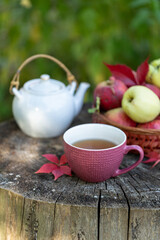 Tea in the apple orchard, a basket with ripe apples