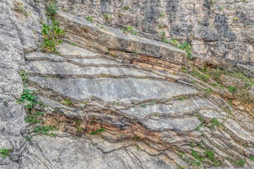 Texture of layered rock in the mountains of Budva, Montenegro. Natural gray-green stone geometric pattern