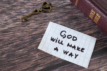 God will make a way, handwritten quote on paper with ancient key and closed holy bible book on wood. Faithful promise of Jesus Christ, Christian direction and encouragement, biblical concept.