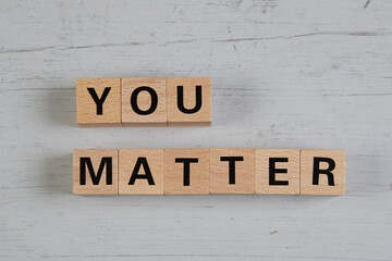 wooden blocks  in a white and grey board with the text you matter
