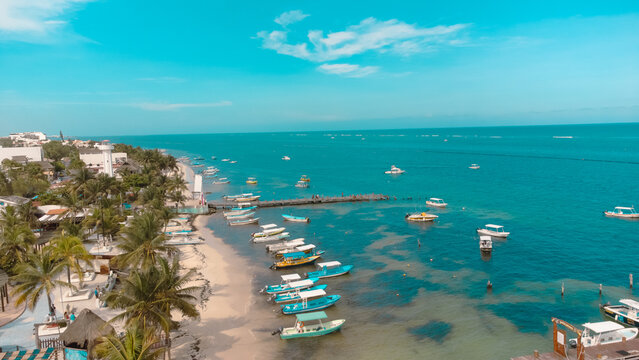 Barcos en el puerto de Puerto Morelos, Quintana Roo junto a la playa y el mar.