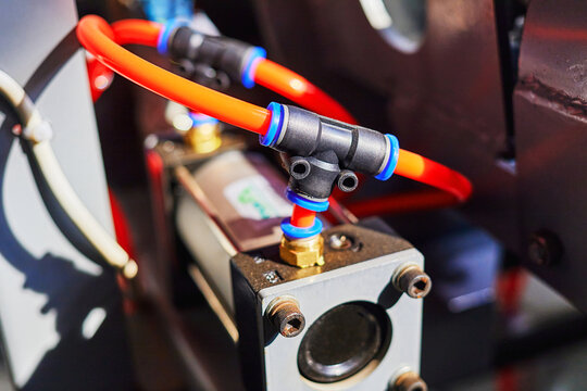 orange duct tubes of pneumatic system connected to the pneumatic cylinder