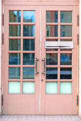 Pink wooden door with square glass