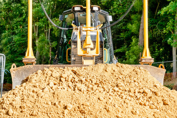 Roadworks and bulldozer levelling stone on top of geogrid plastic mesh © Iryna