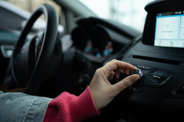 Girl's Hands Increasing the Volume on a Modern Car Radio