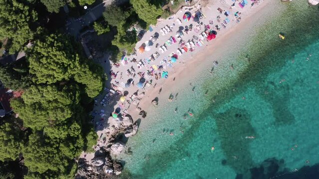 Typical pebble beach in Croatia on a busy day. Beaches narrow stretch