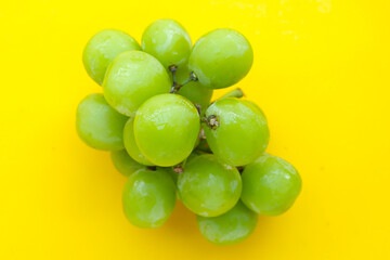 Shine muscat grape on yellow background.