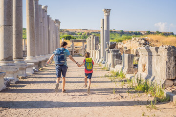 dad and son tourists at the ruins of ancient city of Perge near Antalya Turkey. Traveling with kids concept - obrazy, fototapety, plakaty