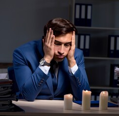 Businessman working late in office with candle light