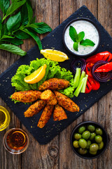 Kibbeh - Arabic style seared meatballs mixed with bulgur groats and mint yogurt on wooden table 