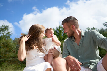 The white Caucasian family relaxing on the beach with their 1 year old baby girl. Latvia