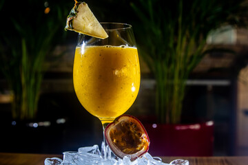Yellow tropical drink cocktail in a glass. Passion fruit, lemon, rum.