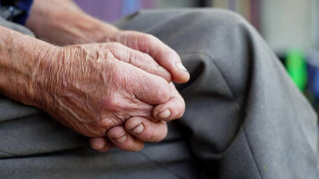 The hand of a young boy touches the hands of an old man. Over time, human skin becomes covered with wrinkles. High quality 4k footage