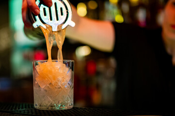 woman hand bartender making cocktail in glass on the bar counter