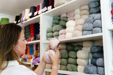 Woman looking at the yarn balls at the hobby shop