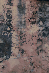 Close-up of a concrete wall with cracks and stains. Paint peeled off.
