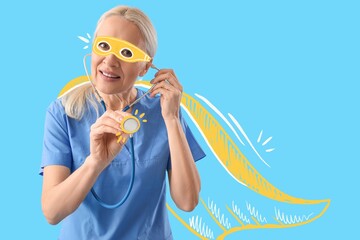 Female doctor in superhero costume and with stethoscope on blue background