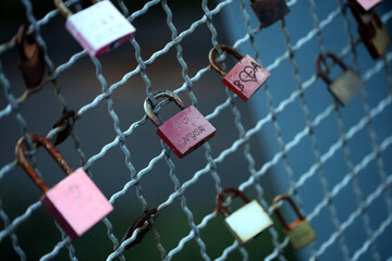 Old and new locks with names and dates written on them couples connection in love lock on a bridge as a sign of love in Dorsten Germany close up high quality instant printings