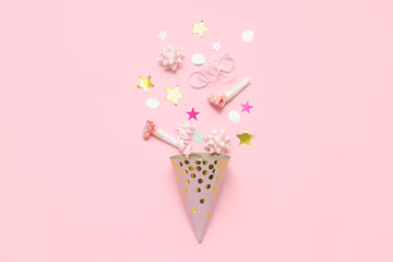 Composition with party hat, whistles and confetti on pink background