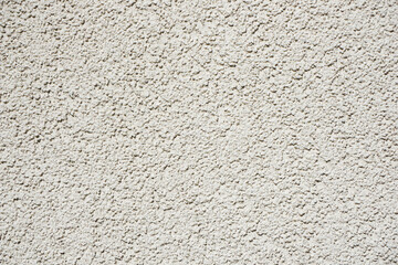 Stucco wall texture. White concrete surface background. Beige plaster wall pattern. Distressed noise backdrop for graphic design. Rough noise background. Small stones pattern. Grain texture.