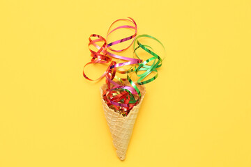 Composition with ice cream cone and confetti on color background