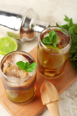 Glasses of tasty Cuba Libre cocktail on light background