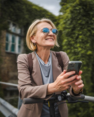 Woman with electric kick scooter use mobile phone smartphone send sms