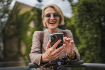 Woman with electric kick scooter use mobile phone smartphone send sms