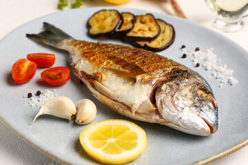 Plate with tasty grilled dorado fish on table