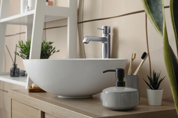 Sink bowl and bath accessories on table in bathroom