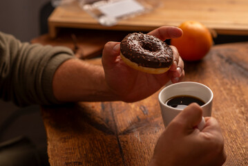 male hands holding donut at the table