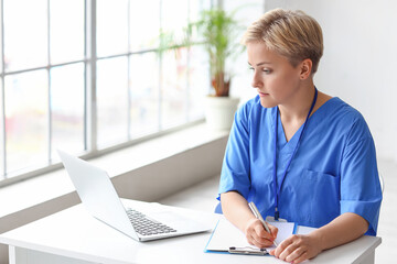 Female medical intern working at reception in clinic