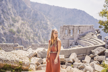 Fototapeta premium Woman tourist explores Stunning Ancient Theater of Termessos Ancient City turkiye, GO Everywhere